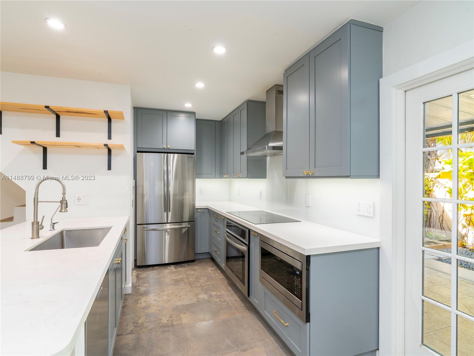 8236 Southwest 103rd Avenue Miami, FL 33173 - Photo 9 of 24 a kitchen with stainless steel appliances a sink stove and refrigerator