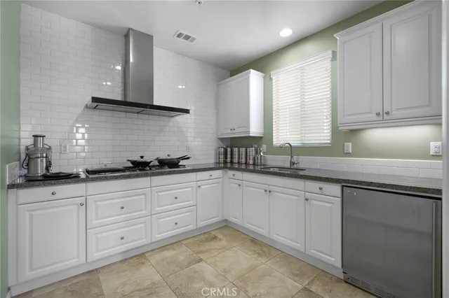 a kitchen with granite countertop white cabinets sink and stainless steel appliances