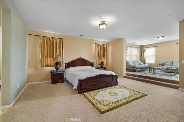 a spacious bedroom with a bed and a dresser