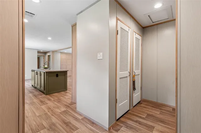 a view of a hallway with wooden floor and a bathroom
