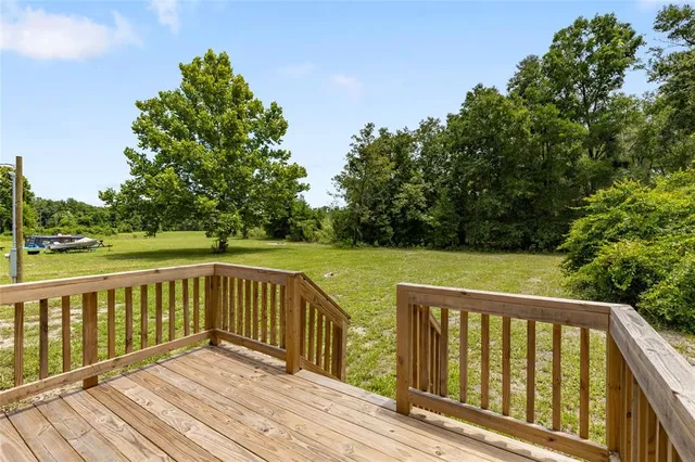 a front view of house with yard and trees in the background