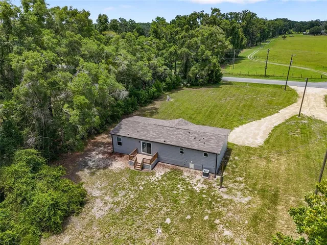 an aerial view of a house with a garden and lake view