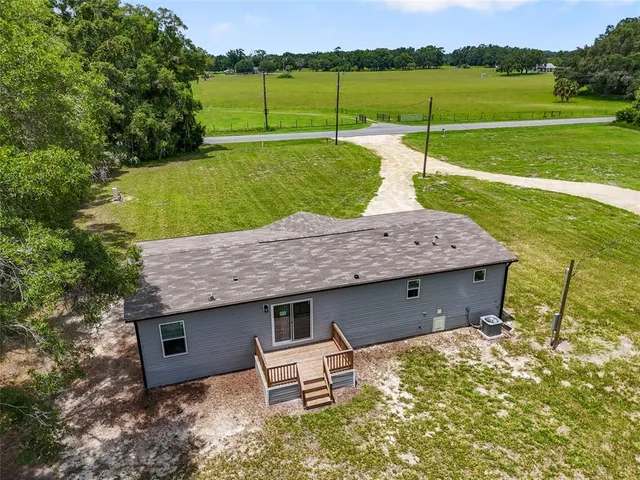 an aerial view of a house with a big yard