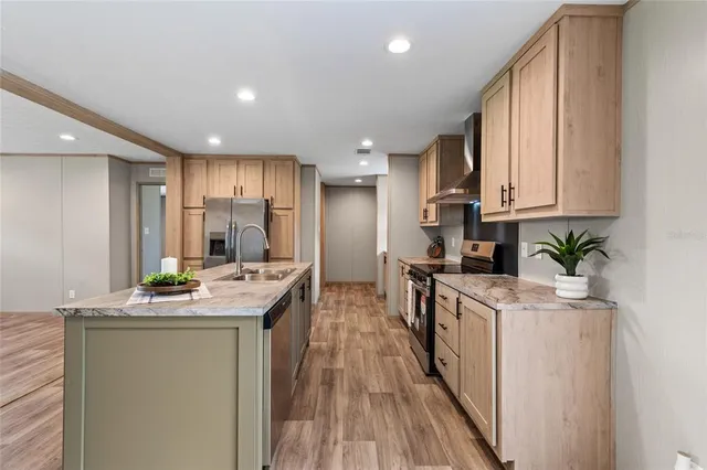 a kitchen with stainless steel appliances granite countertop a lot of counter space and wooden floors