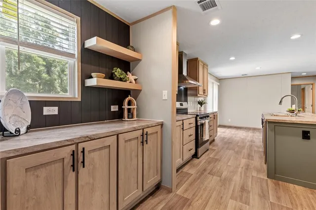a kitchen with kitchen island a counter top space a sink stainless steel appliances and windows