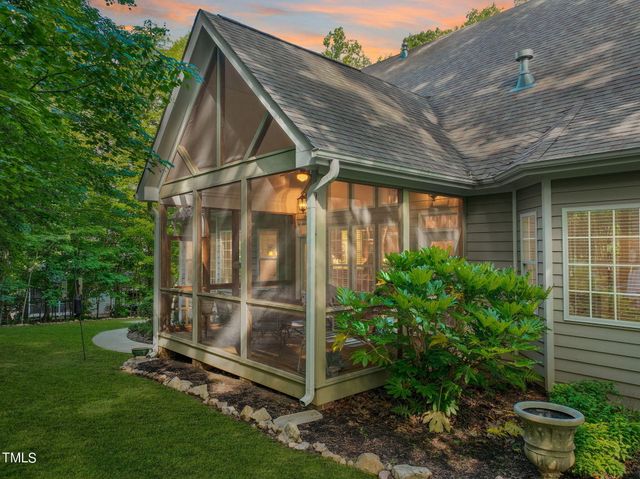 a view of a house with a big yard and large trees