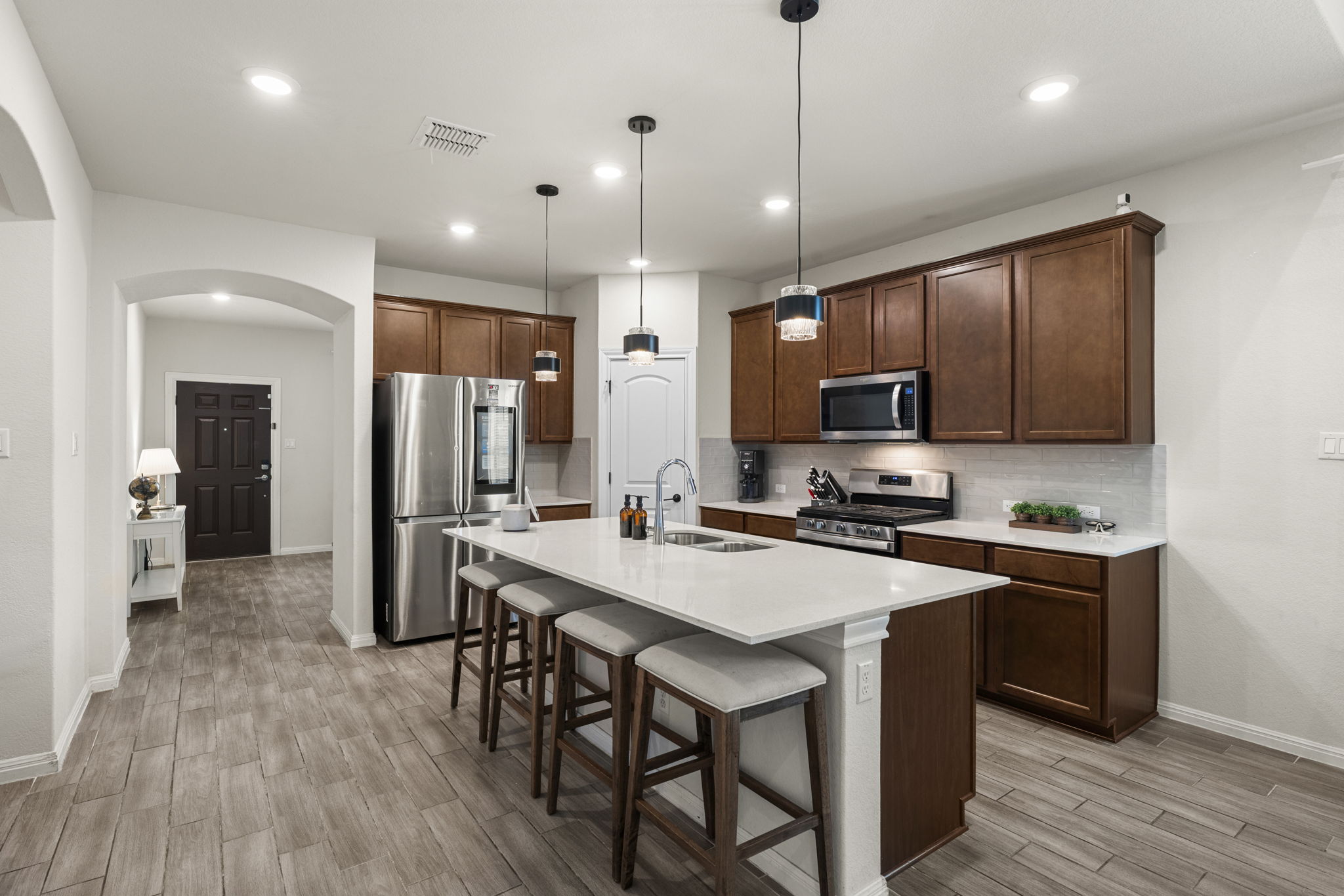 548 Purple Heart Drive Buda, TX 78610 - Photo 3 of 35 Culinary adventures await in this naturally illuminated kitchen, featuring a central island with bar seating.