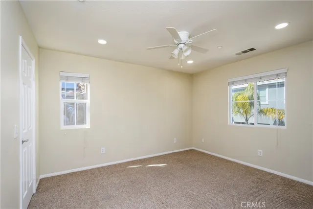 a bathroom with a toilet a sink a mirror and a window