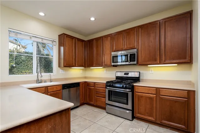 a kitchen with stainless steel appliances granite countertop a refrigerator and a sink
