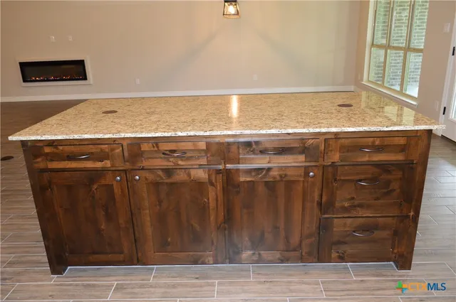 a kitchen with granite countertop white cabinets and a sink