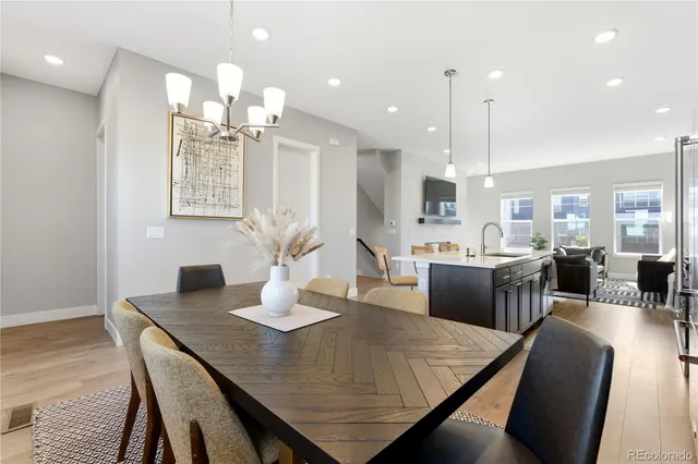 a kitchen with a dining table chairs refrigerator and cabinets