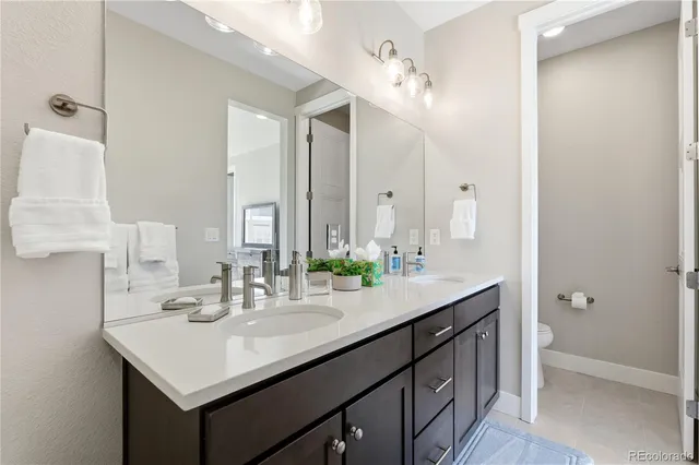 a bathroom with a double vanity sink toilet and shower