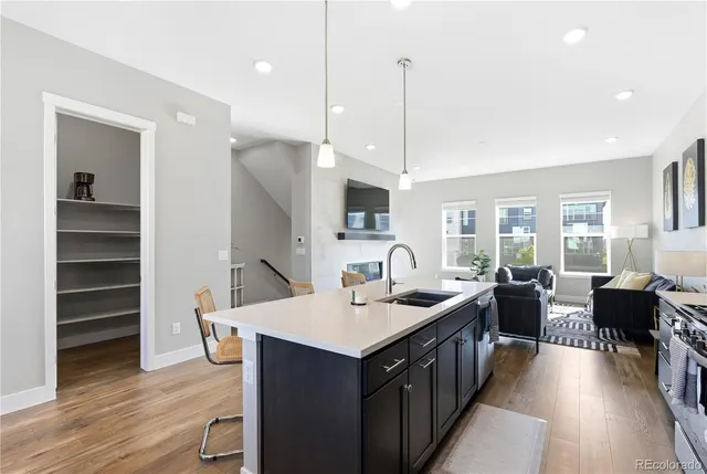 a open dining room with stainless steel appliances kitchen island granite countertop a table chairs and a microwave