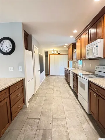 a large kitchen with stainless steel appliances granite countertop a stove a sink and a refrigerator