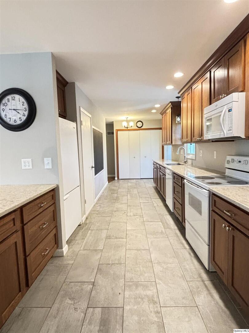 802 West Main Street La Harpe, IL 61450 - Photo 11 of 25 a large kitchen with stainless steel appliances granite countertop a stove a sink and a refrigerator
