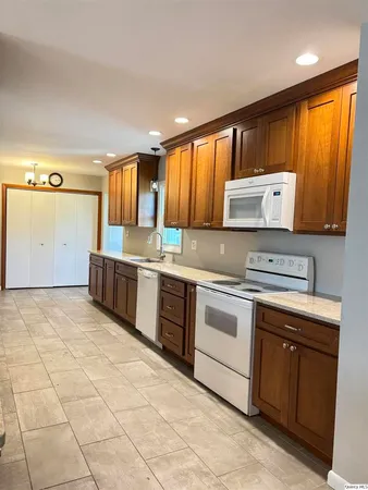 a kitchen with stainless steel appliances granite countertop a stove a sink and a microwave