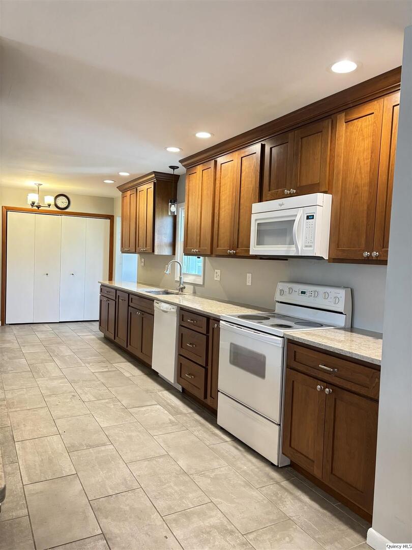 802 West Main Street La Harpe, IL 61450 - Photo 12 of 25 a kitchen with stainless steel appliances granite countertop a stove a sink and a microwave