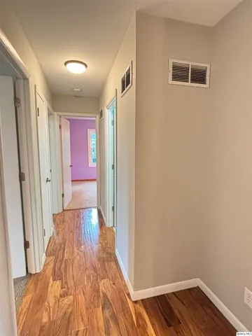 a view of hallway with wooden floor