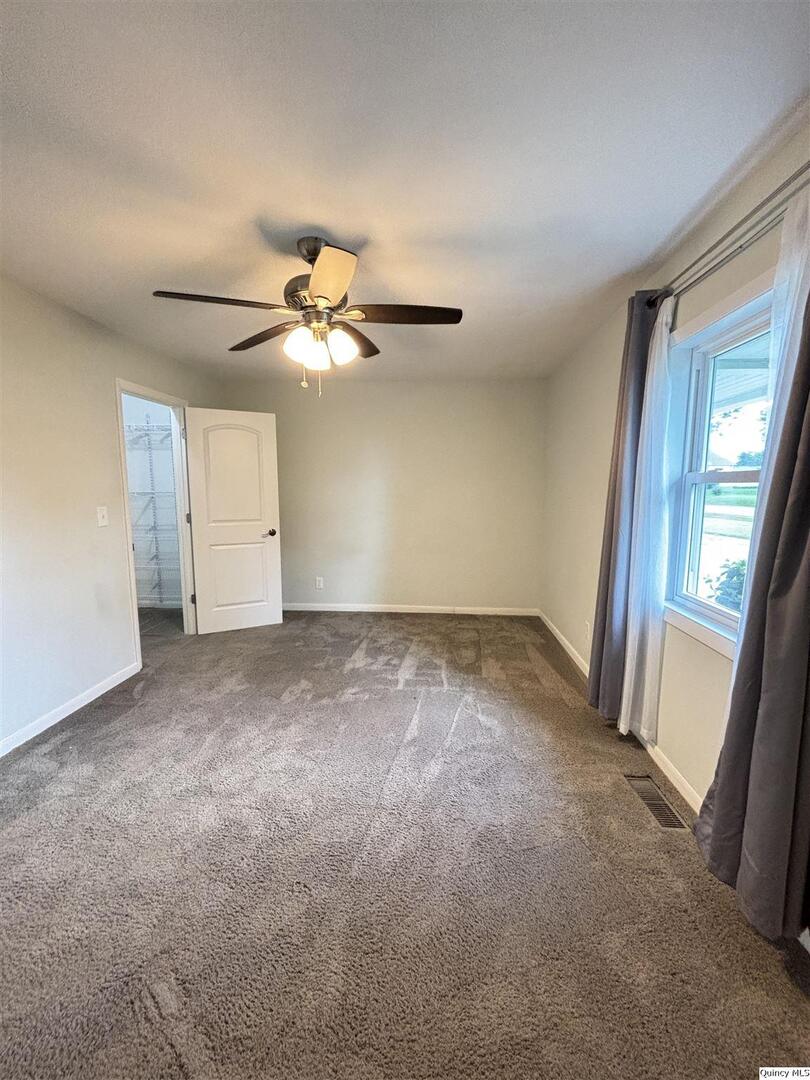 802 West Main Street La Harpe, IL 61450 - Photo 18 of 25 a view of a livingroom with a ceiling fan and window