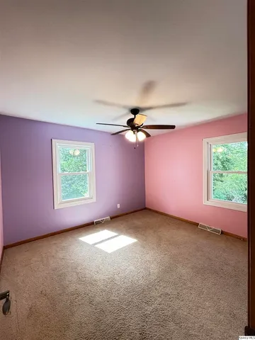 a view of a livingroom with a window and a ceiling fan