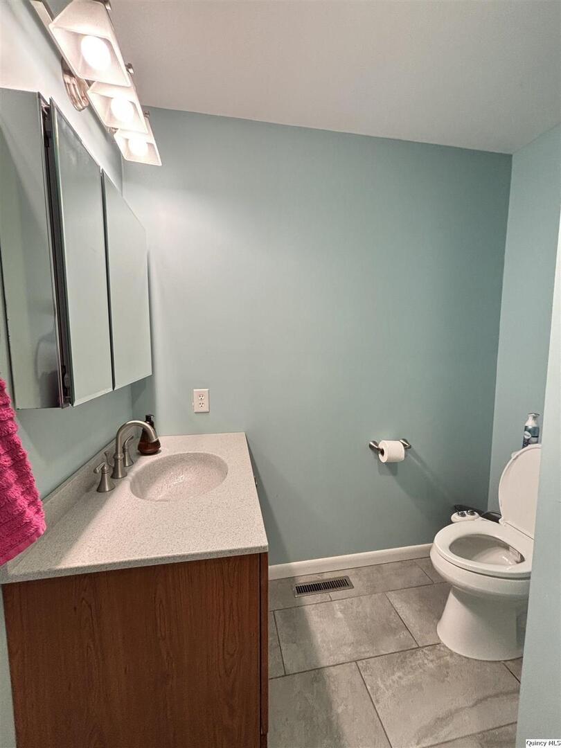 802 West Main Street La Harpe, IL 61450 - Photo 7 of 25 a bathroom with a sink and a toilet