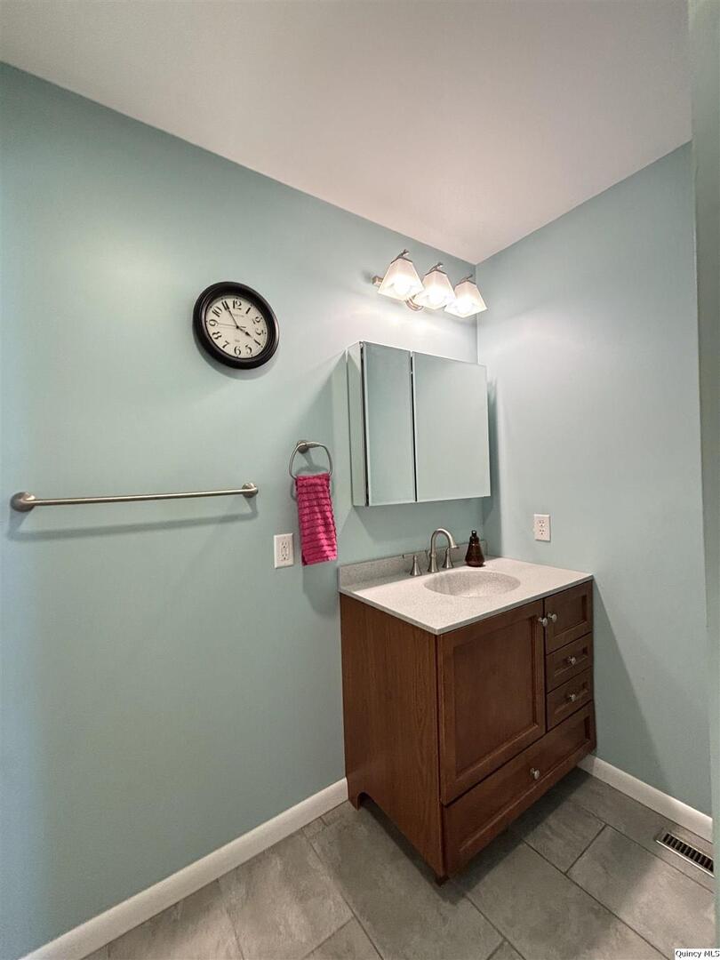 802 West Main Street La Harpe, IL 61450 - Photo 8 of 25 a bathroom with a sink and a mirror