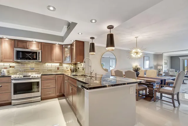 a open kitchen with stainless steel appliances granite countertop a stove and a sink