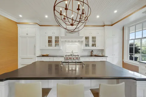 a large kitchen with stainless steel appliances granite countertop a stove and a wooden floors