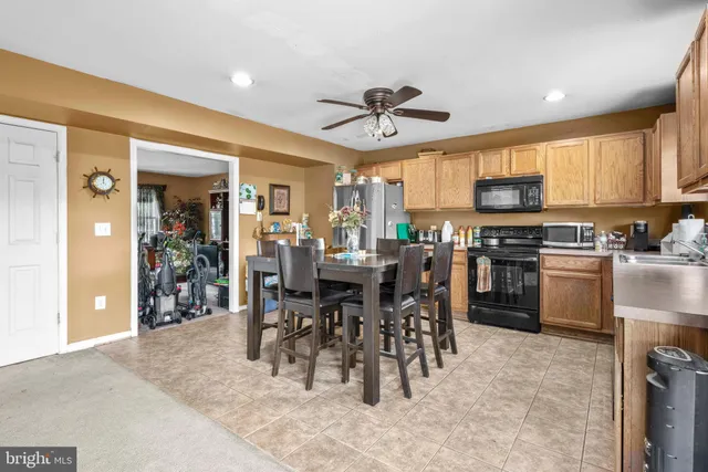 a kitchen with stainless steel appliances granite countertop a stove a sink dishwasher and a microwave oven with white cabinets