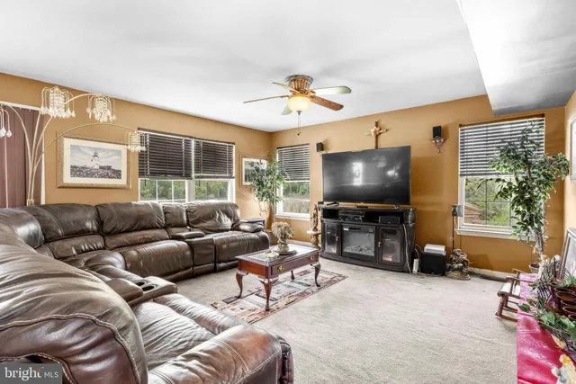 a living room with furniture a ceiling fan and a window