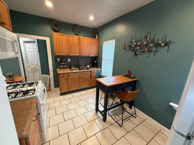 a kitchen with stainless steel appliances a stove a refrigerator and a dining table