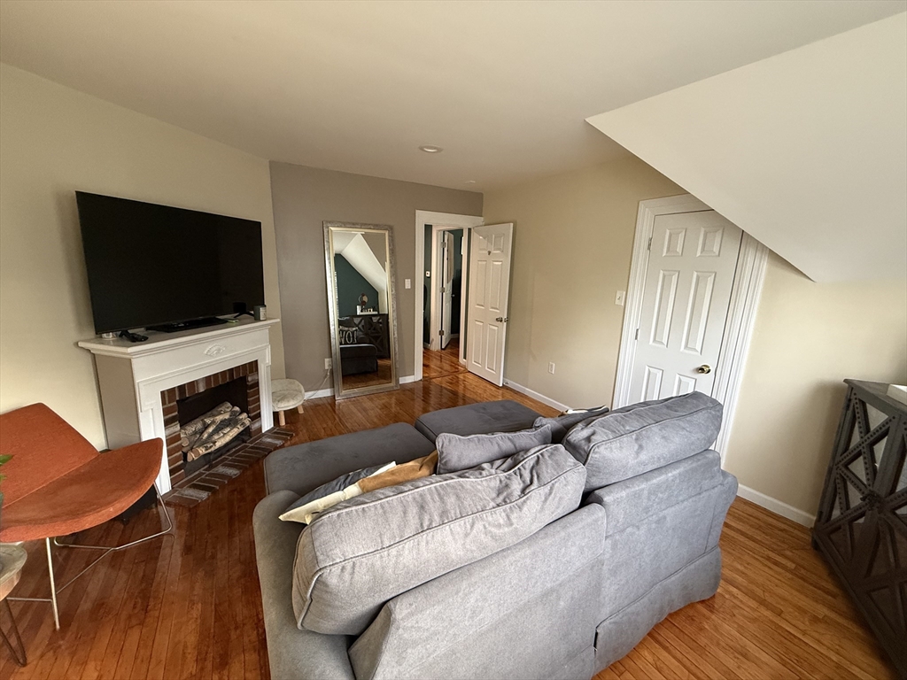 19 Oliver Street Worcester, MA 01603 - Photo 7 of 26 a living room with furniture a flat screen tv and a fireplace