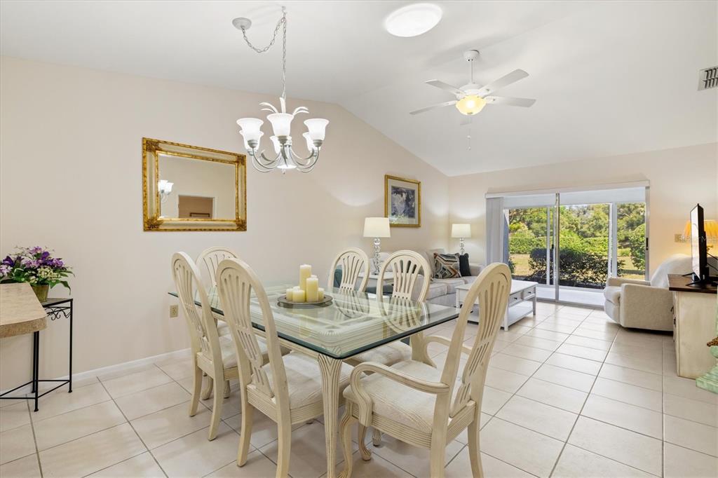 608 Pinebrook Crescent, Unit 8 Venice, FL 34285 - Photo 13 of 75 a dining room with furniture a large window and a chandelier
