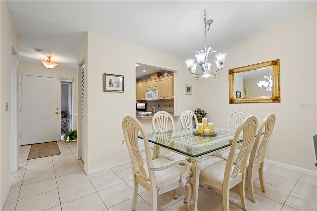 608 Pinebrook Crescent, Unit 8 Venice, FL 34285 - Photo 14 of 75 a view of a dining room with furniture and chandelier