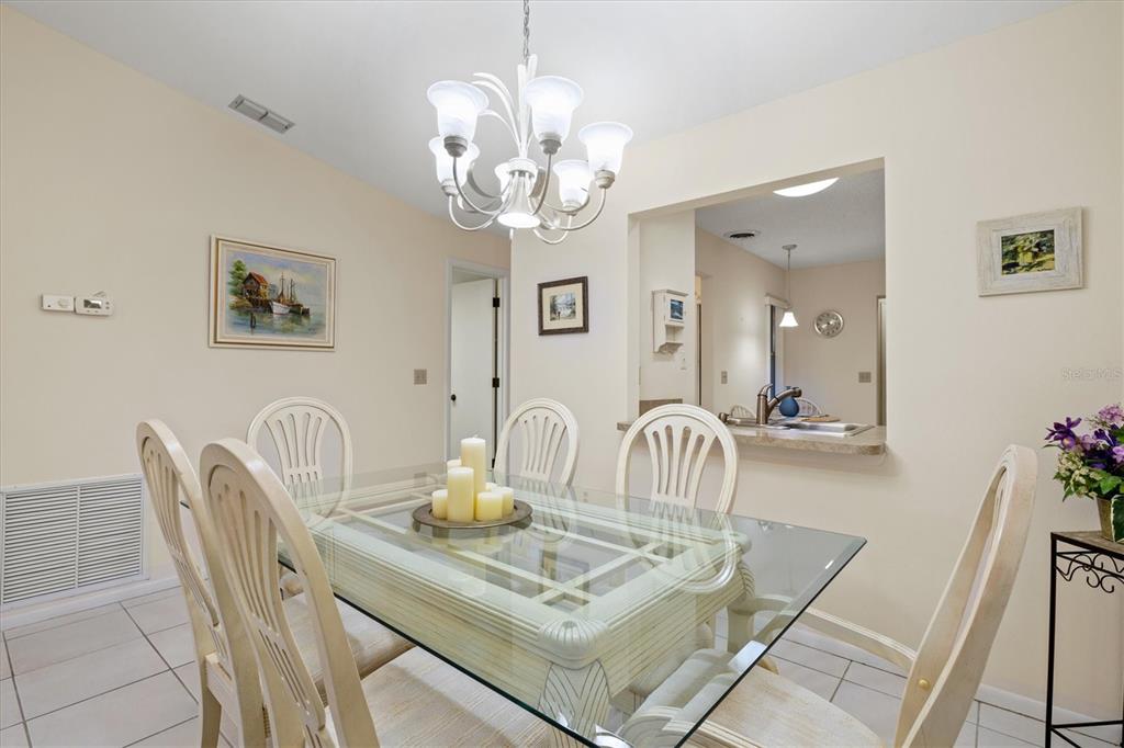 608 Pinebrook Crescent, Unit 8 Venice, FL 34285 - Photo 15 of 75 a dining room with furniture and chandelier