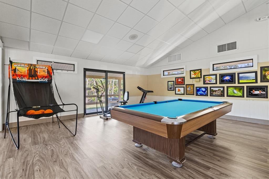 608 Pinebrook Crescent, Unit 8 Venice, FL 34285 - Photo 54 of 75 a room with wooden floor pool table and windows