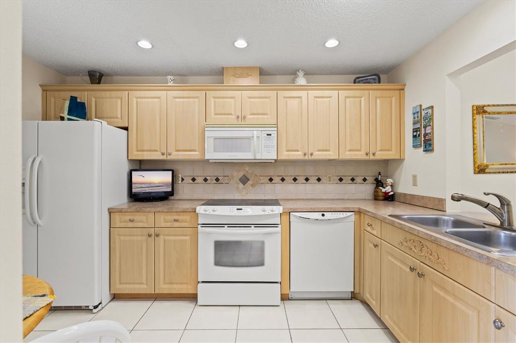 608 Pinebrook Crescent, Unit 8 Venice, FL 34285 - Photo 6 of 75 a kitchen with white cabinets sink and white appliances