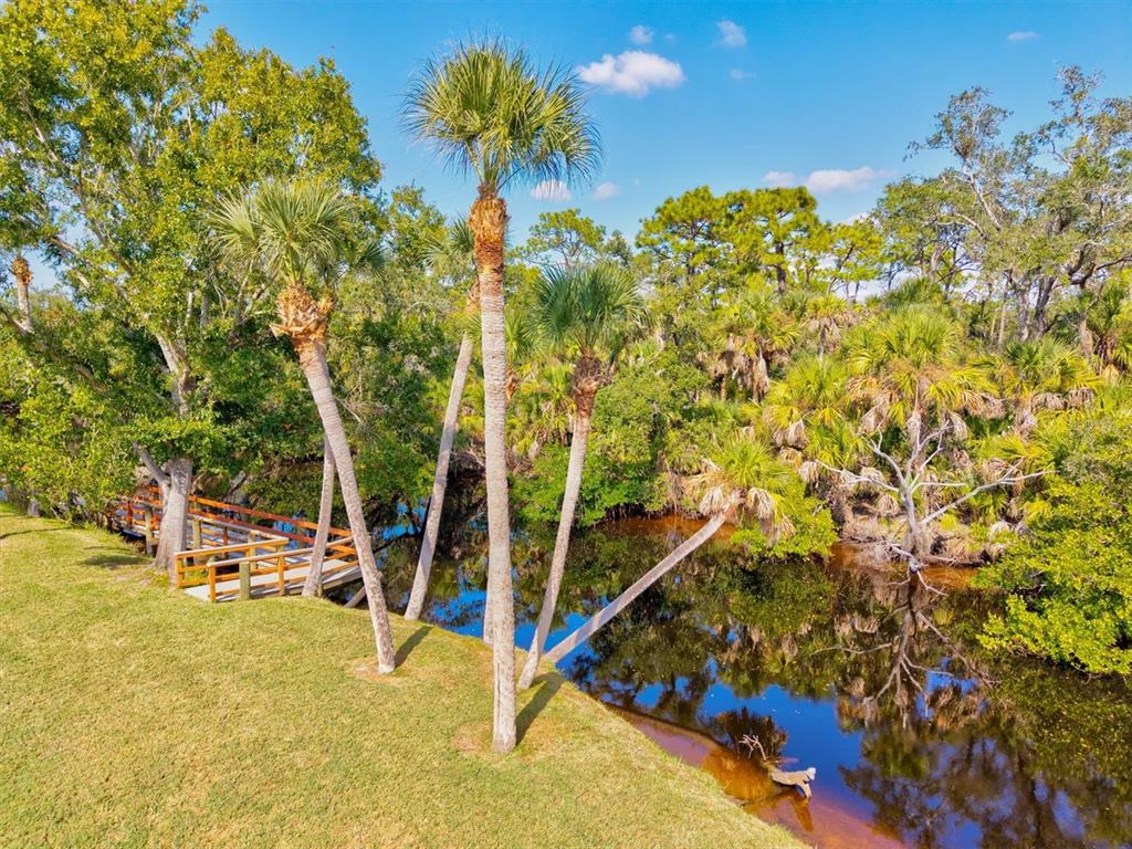 608 Pinebrook Crescent, Unit 8 Venice, FL 34285 - Photo 64 of 75 a view of a swimming pool with a bench and trees