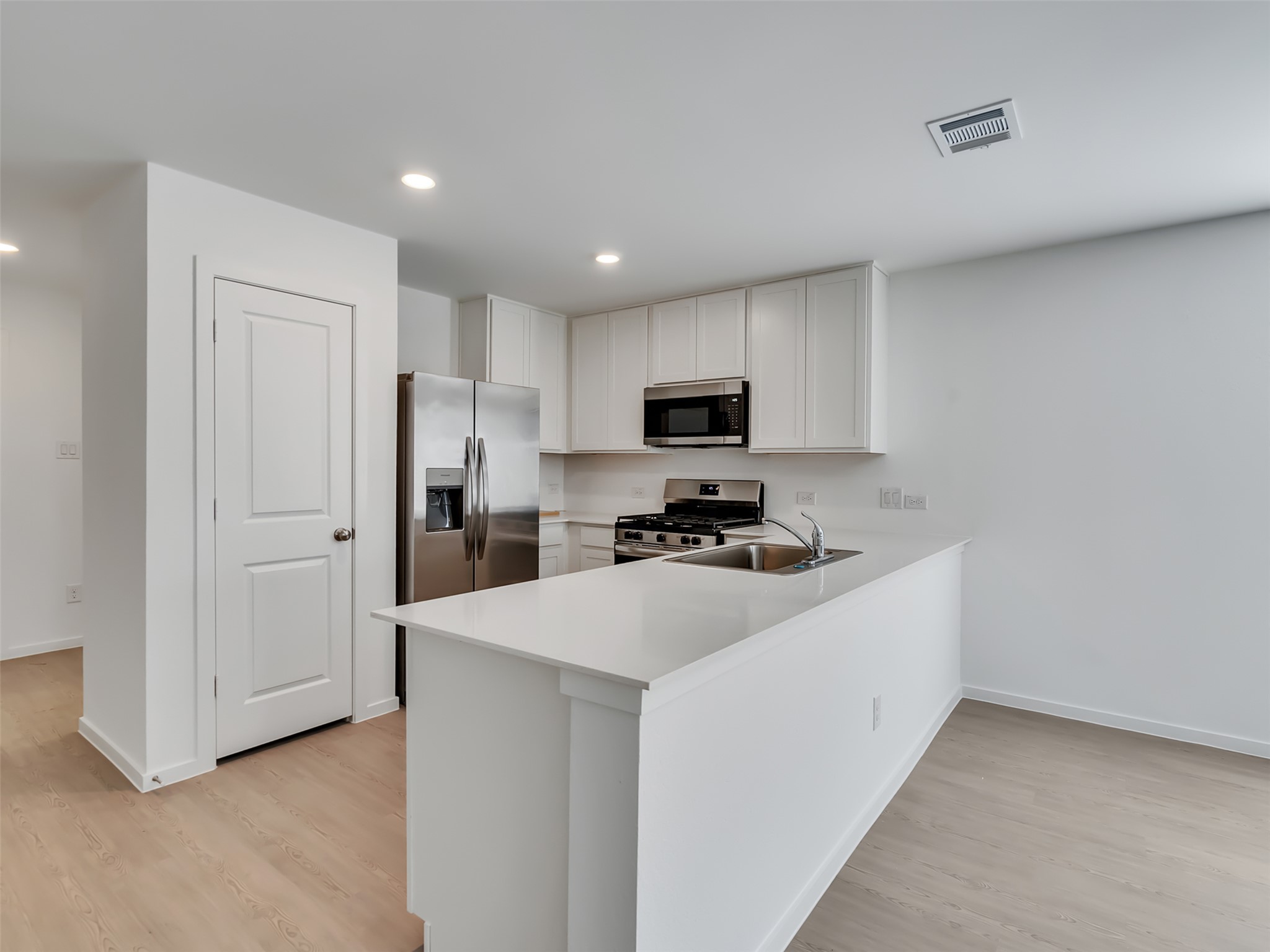3041 Colusa Rdg Drive Katy, TX 77493 - Photo 4 of 26 a kitchen with a refrigerator a microwave and white cabinets