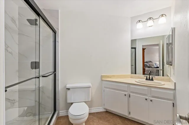 a bathroom with a granite countertop shower and a sink