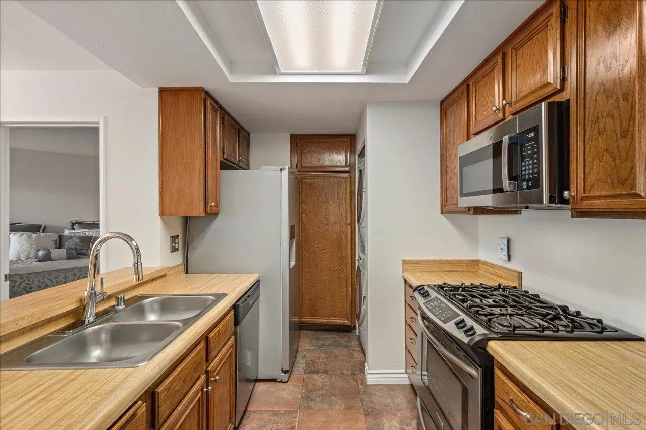 3003 Blue Oak Court Spring Valley, CA 91978 - Photo 7 of 39 a kitchen that has a sink wooden cabinets and stainless steel appliances