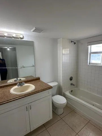 a bathroom with a granite countertop sink a toilet and a bathtub