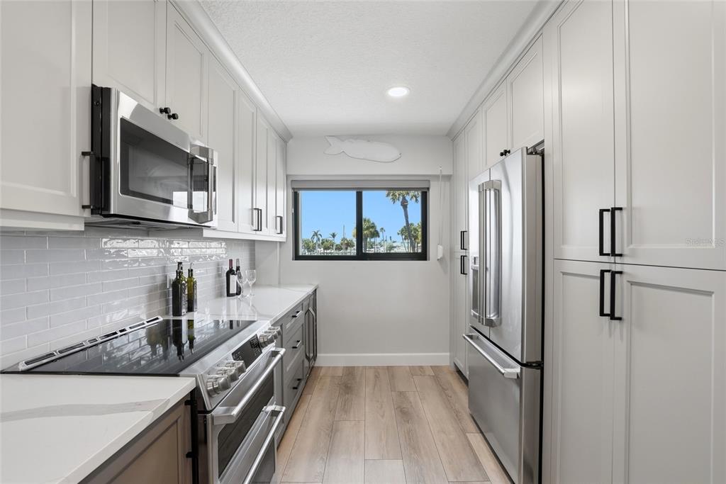 363 Pinellas Bayway South, Unit 29 Tierra Verde, FL 33715 - Photo 19 of 59 a kitchen with stainless steel appliances a refrigerator a sink and white cabinets