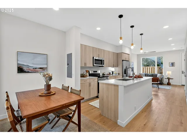 a kitchen with a table chairs refrigerator and microwave