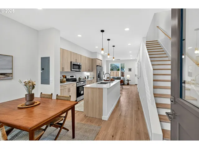 a open kitchen with a table chairs refrigerator and microwave