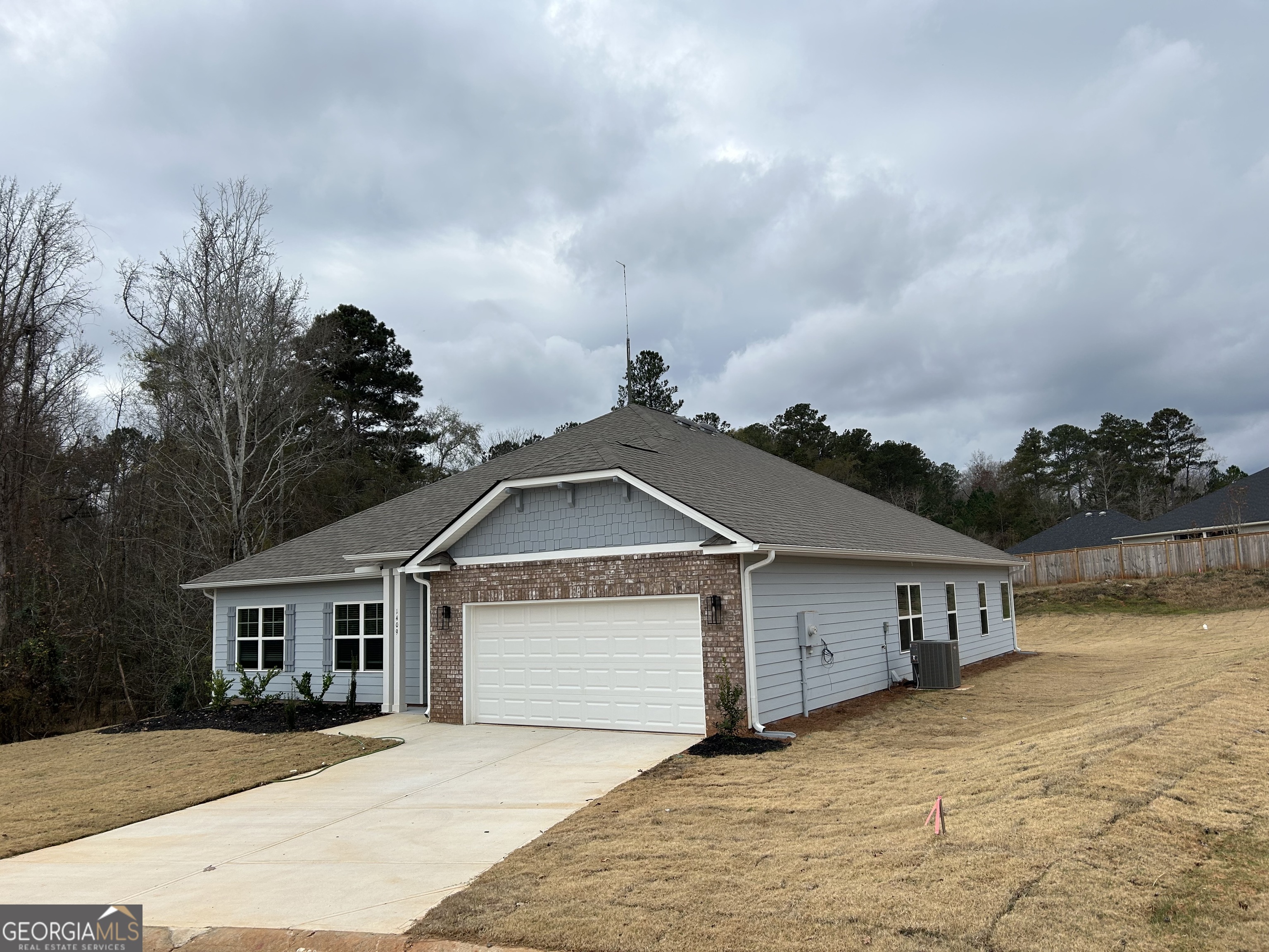 1409 Barrington Pl Way Macon, GA 31220 - Photo 2 of 17 a front view of a house with a yard and garage
