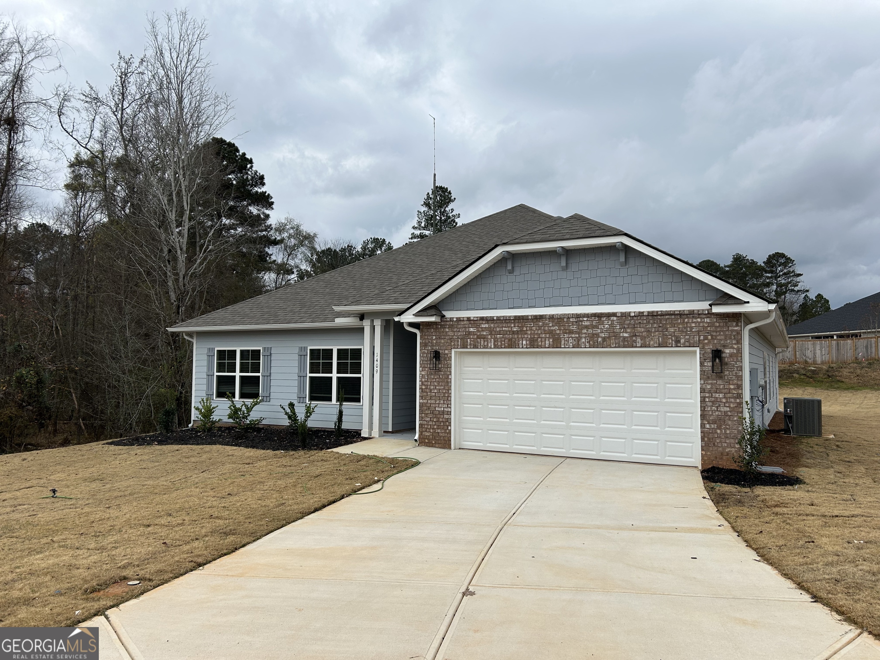 1409 Barrington Pl Way Macon, GA 31220 - Photo 3 of 17 a front view of a house with a yard and garage
