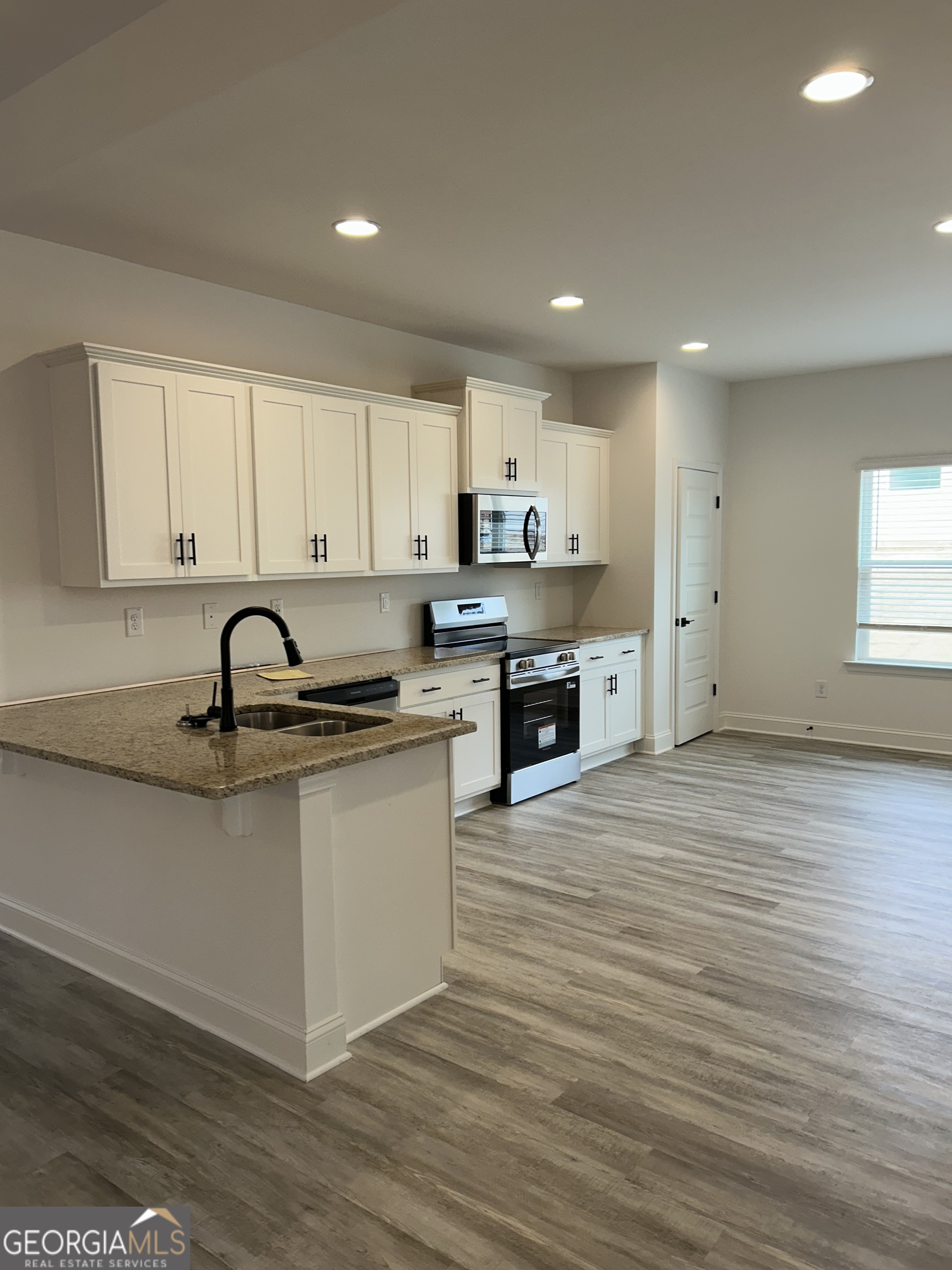 1409 Barrington Pl Way Macon, GA 31220 - Photo 6 of 17 a large kitchen with stainless steel appliances granite countertop a stove a sink a refrigerator and white cabinets with wooden floor