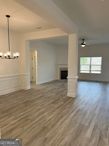 a view of empty room with wooden floor and window
