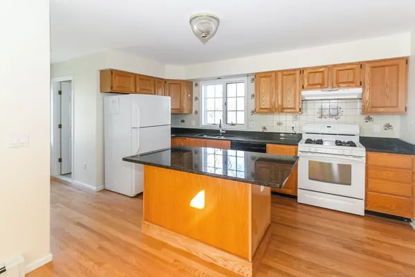 a kitchen with stainless steel appliances granite countertop a stove a sink and a refrigerator